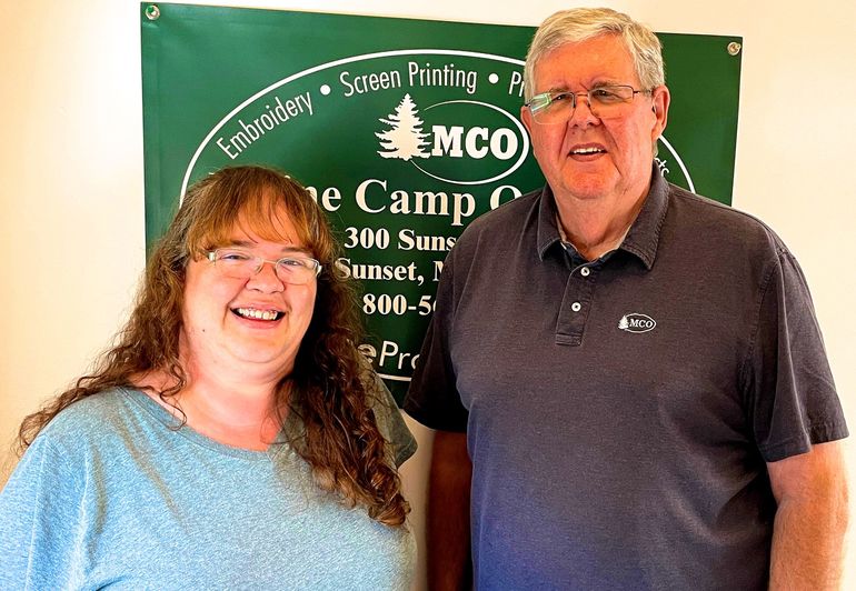 2 people smiling with banner