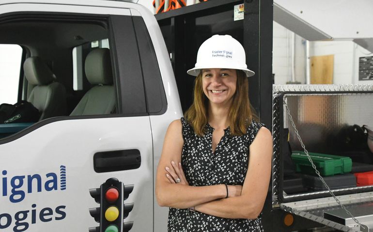person smiling with hardhat and truck