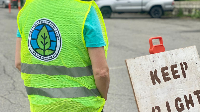 person's back with yellow vest and sign