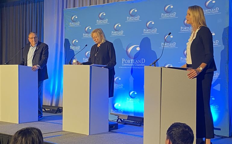 Three people on stage at podiums