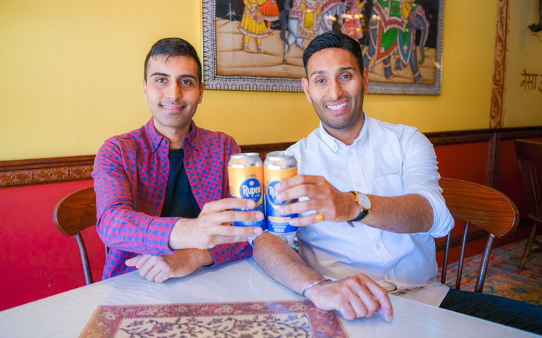 Two guys with raised beer cans 