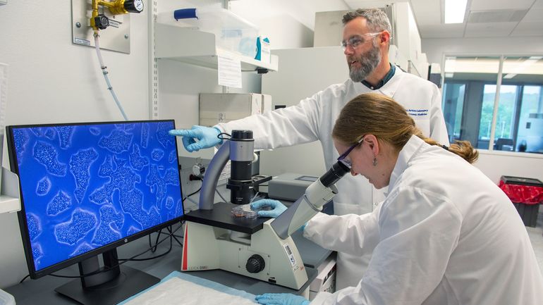 2 people in lab with microscope