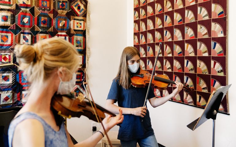 2 people playing violins