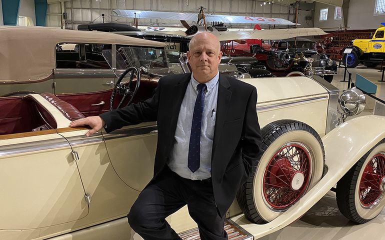 person in tie and suit with antique car