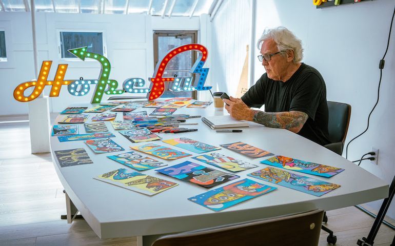 person at table with artworks