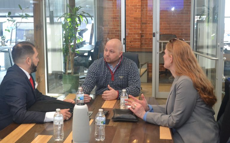 Three people at Cloudport table talking