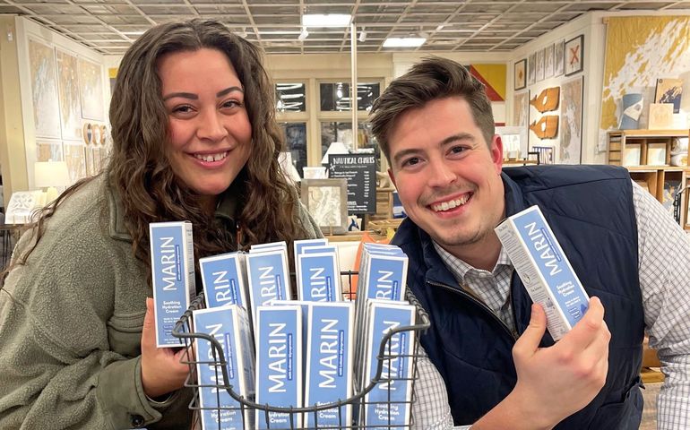 2 people smiling with boxes on display