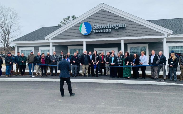 People at bank branch ribbon cutting 