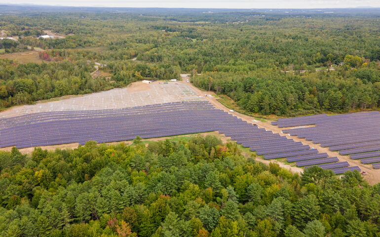aerial of solar field and woods
