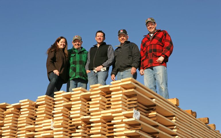 people standing on stack of lumber