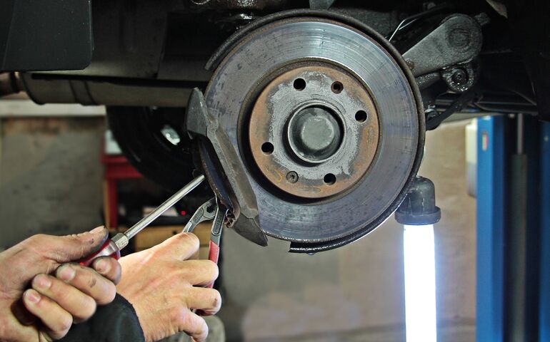 Hands working on a car part 