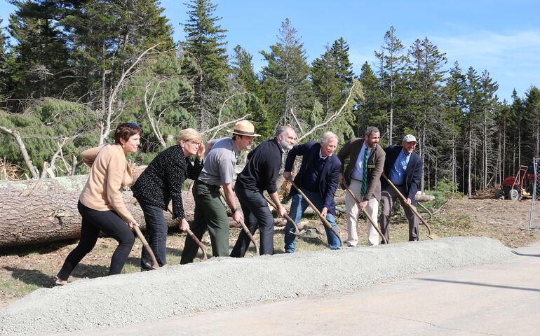 people with shovels and dirt mound