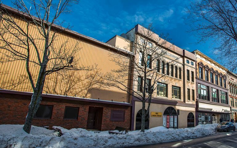 buildings lining street and snowy sidewalk