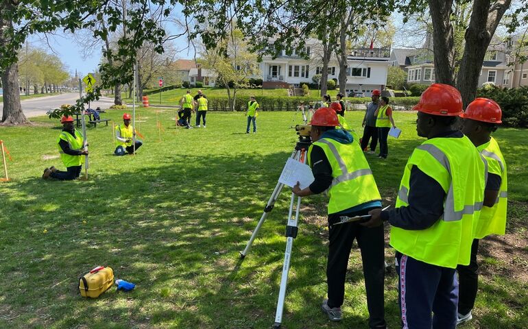 people in hard hats with equipment in field