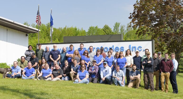 group of people posing in front of sign