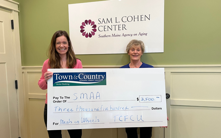 two people holding oversized check