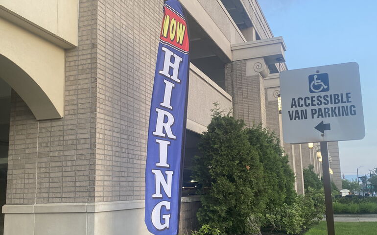 "Now Hiring" Sign outside a hotel parking garage