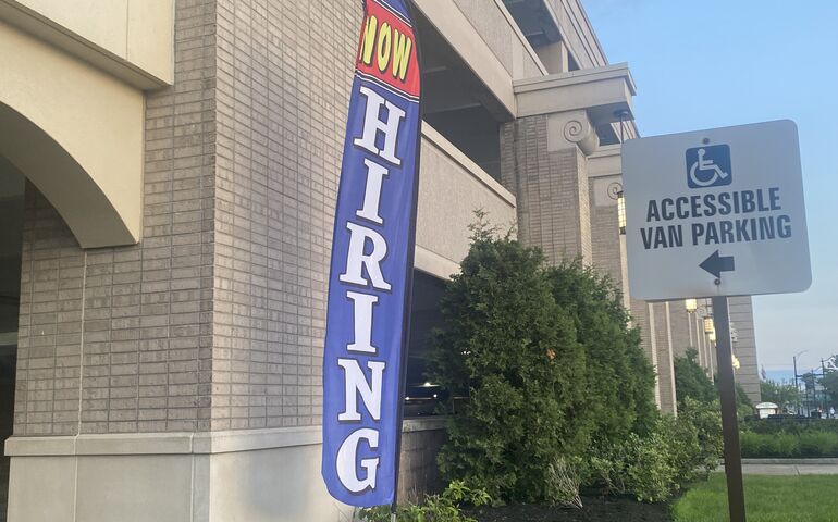 "Now Hiring" Sign outside a hotel parking garage