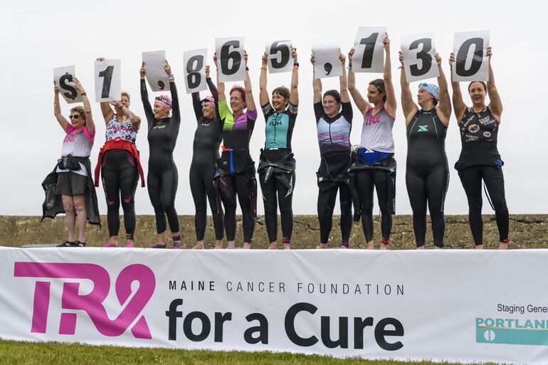 Triathletes holding up numbers 