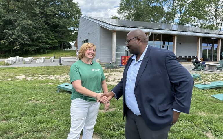 2 people smiling and shaking hands