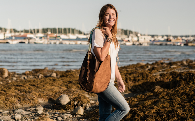 Woman by ocean with handbag 