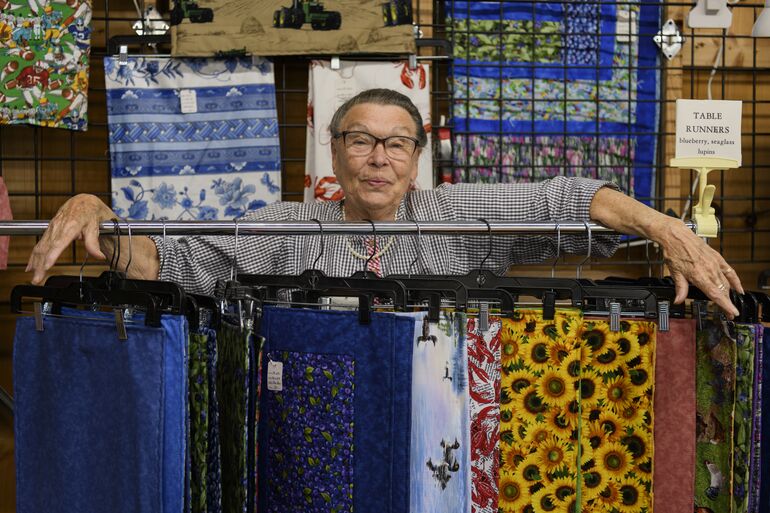 Woman with quilts.
