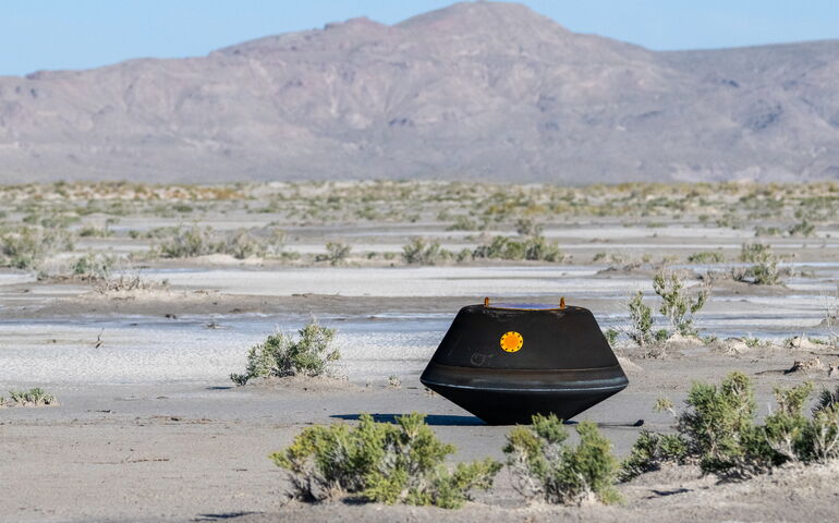 space capsule in desert with scrub around it