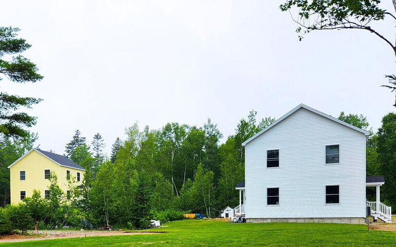 white house and yellow house and lawn and trees