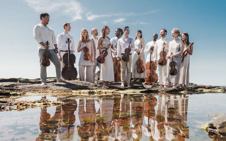 people standing outside in a group reflected by tide pool