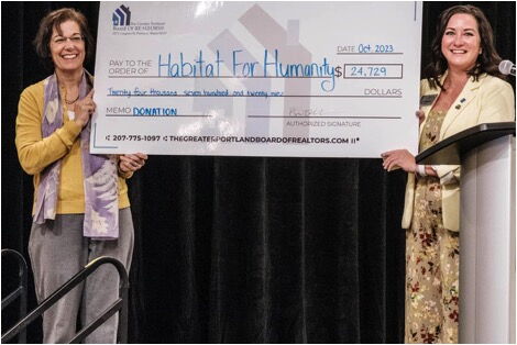 2 people holding up oversize check