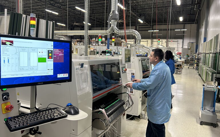 person in blue shop coat with lots of machinery