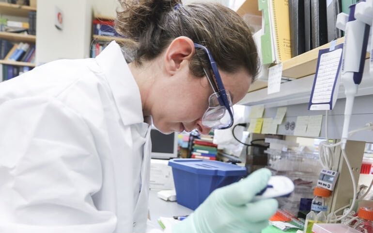 person in protective suiting with research equipment