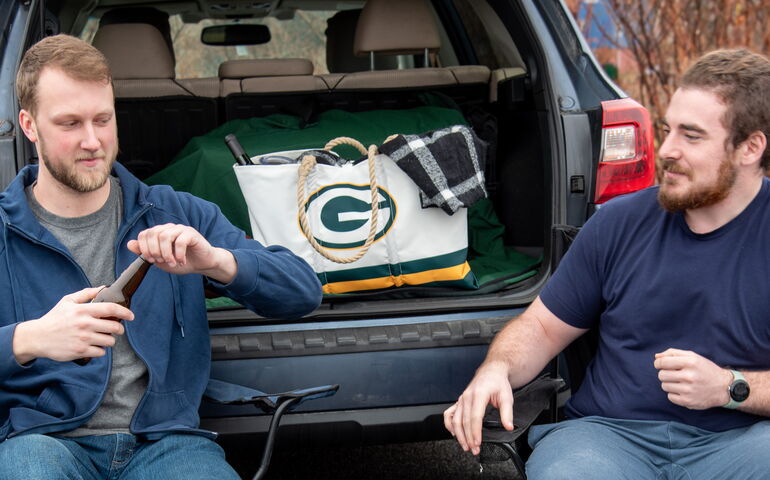 Two guys tailgating at a football game 