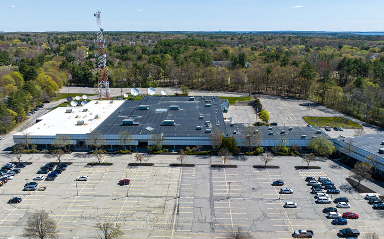 aerial view of big building and parking lot with cars