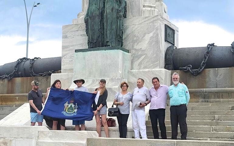 people on stone steps holding flag