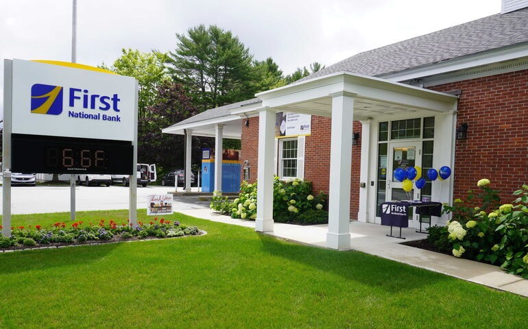 brick building with white painted portico and sign