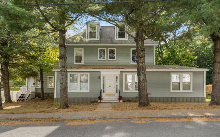 house with olive green siding and trees out front