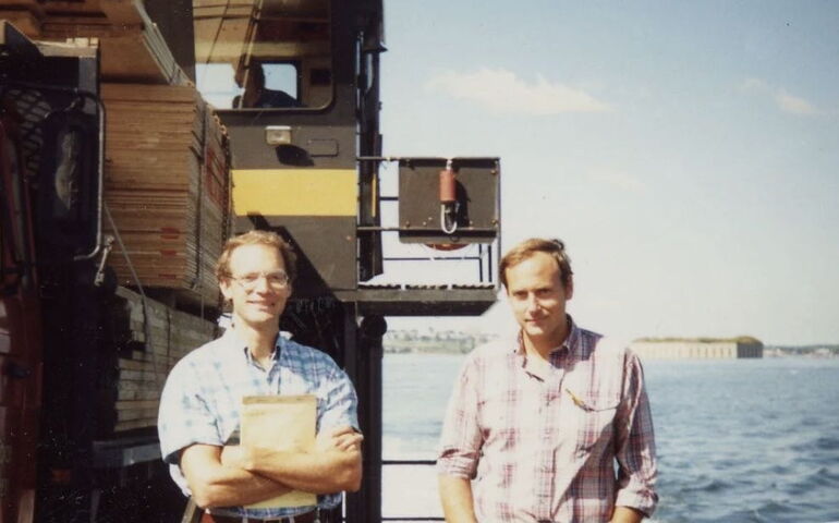 2 people standing by water in old photo