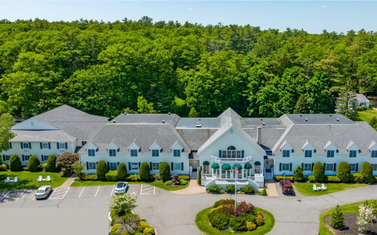 long two story white building and parking lot