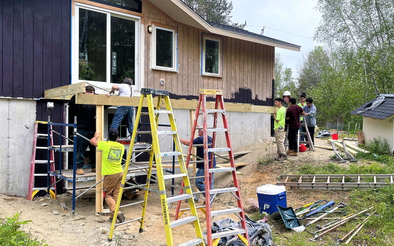 people around house with ladders