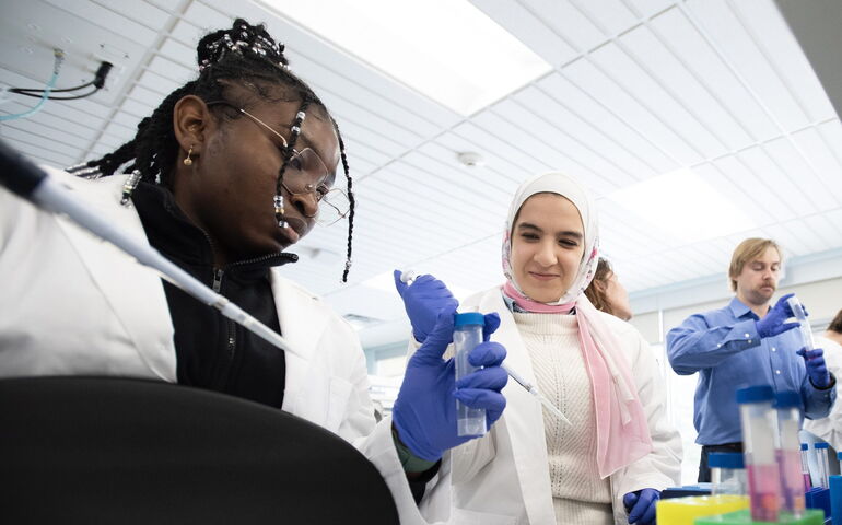 people in white lab coats with test tubes