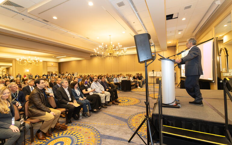 person at podium and people sitting on chairs