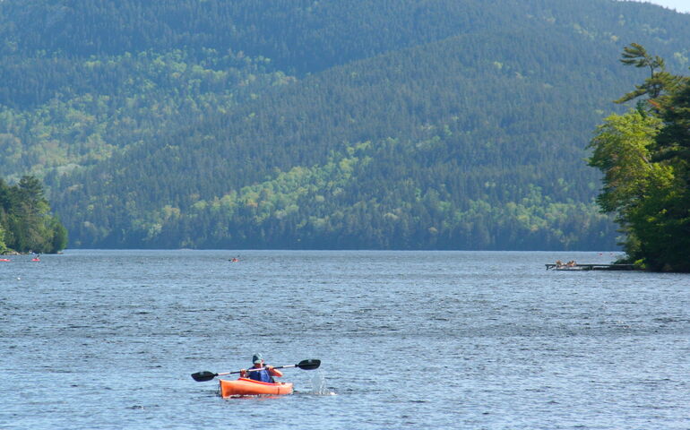 person in kayak with hill in background