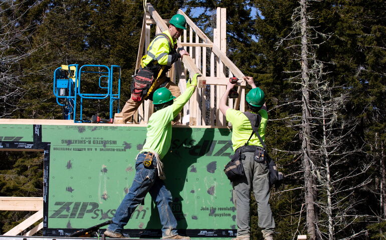 3 people putting  up building parts