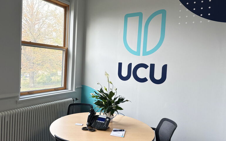 white wall with logo and window and table with chairs