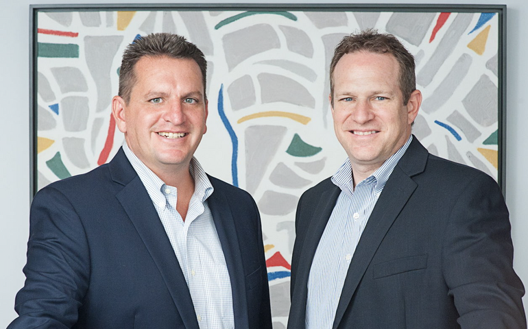 The founding partners of ATX Advisory Services are posing at a counter.