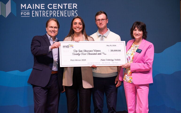 MCE employees pose with award winners holding an oversize check