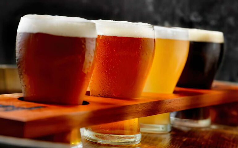 A flight of beer is lined up on a countertop.