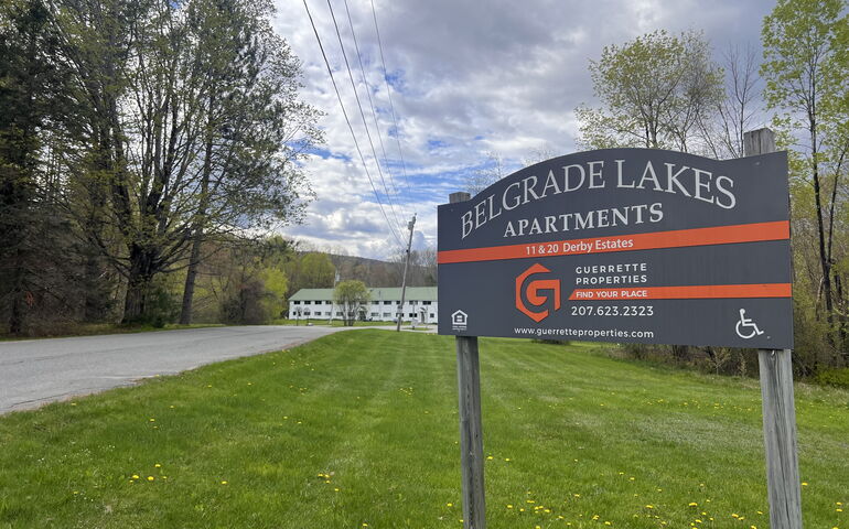 building in background with lawn and sign in foreground