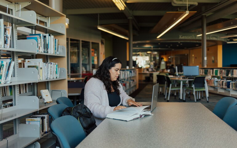Student in library at Thomas College, in Waterville.